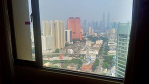 Une vue sur une ville à travers une fenêtre, avec des gratte-ciel en arrière-plan.