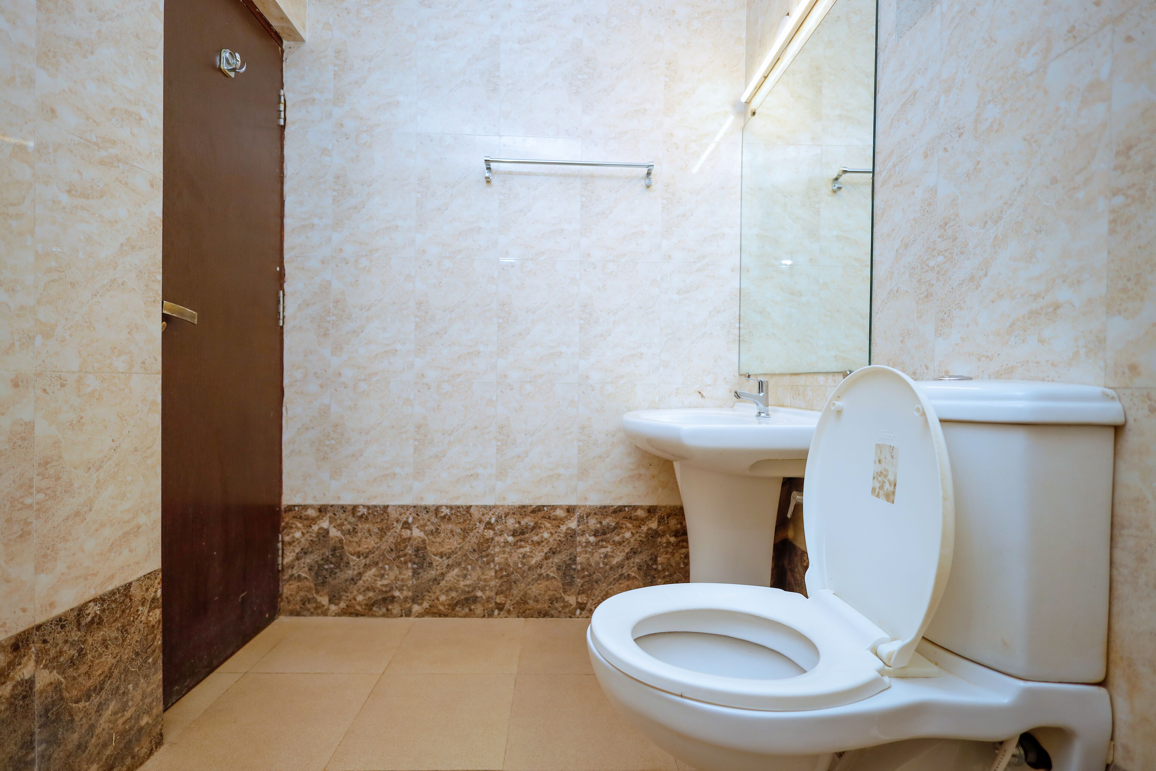 Un baño con inodoro, lavabo y espejo.