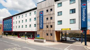 A Travelodge hotel with a modern design, featuring a mix of white and wooden facades, multiple windows, and a sign indicating a restricted height of 3.7 meters. - Travelodge Ipswich (Ipswich)