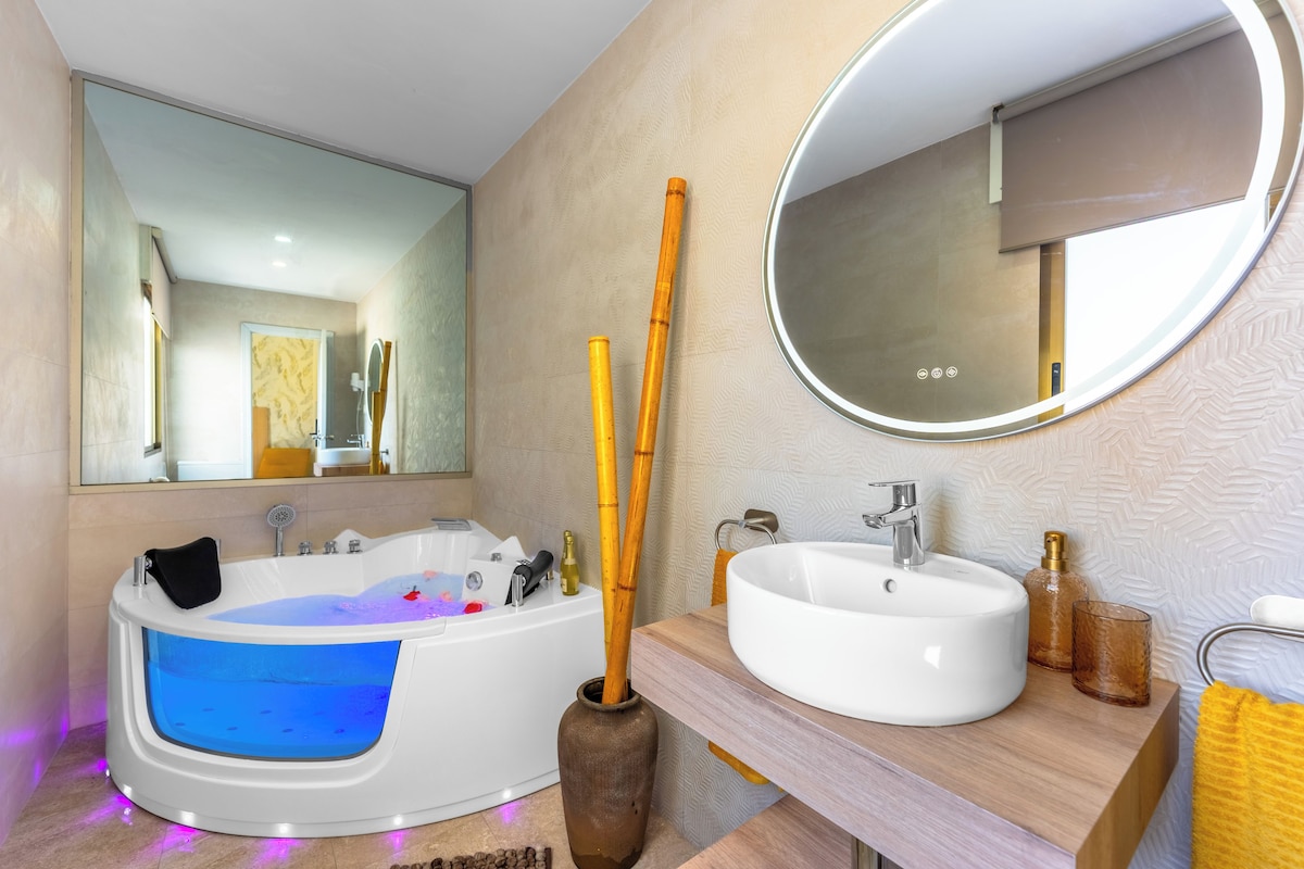 A modern bathroom with a bathtub, a sink, a mirror, and a decorative vase.