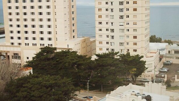 A high-rise hotel with multiple floors, a flat roof, and a view of the sea. - Comodoro Hotel (Comodoro Rivadavia)