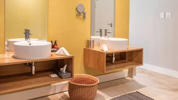 Ein modernes Badezimmer mit zwei Waschbecken, einem Holz-Vanity-Schrank, einem Spiegel und einem Korb.