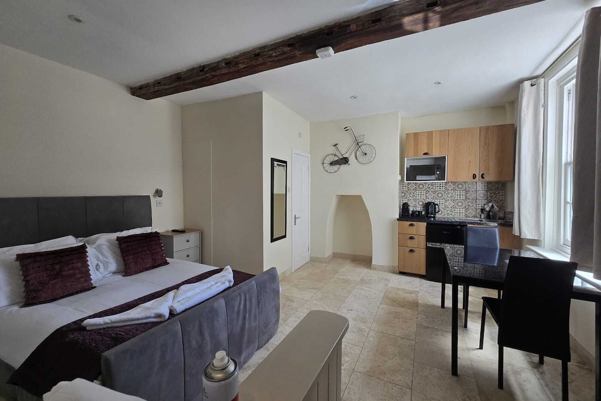 Une chambre à coucher comprenant un lit, une table de chevet et un petit espace bureau avec une chaise.