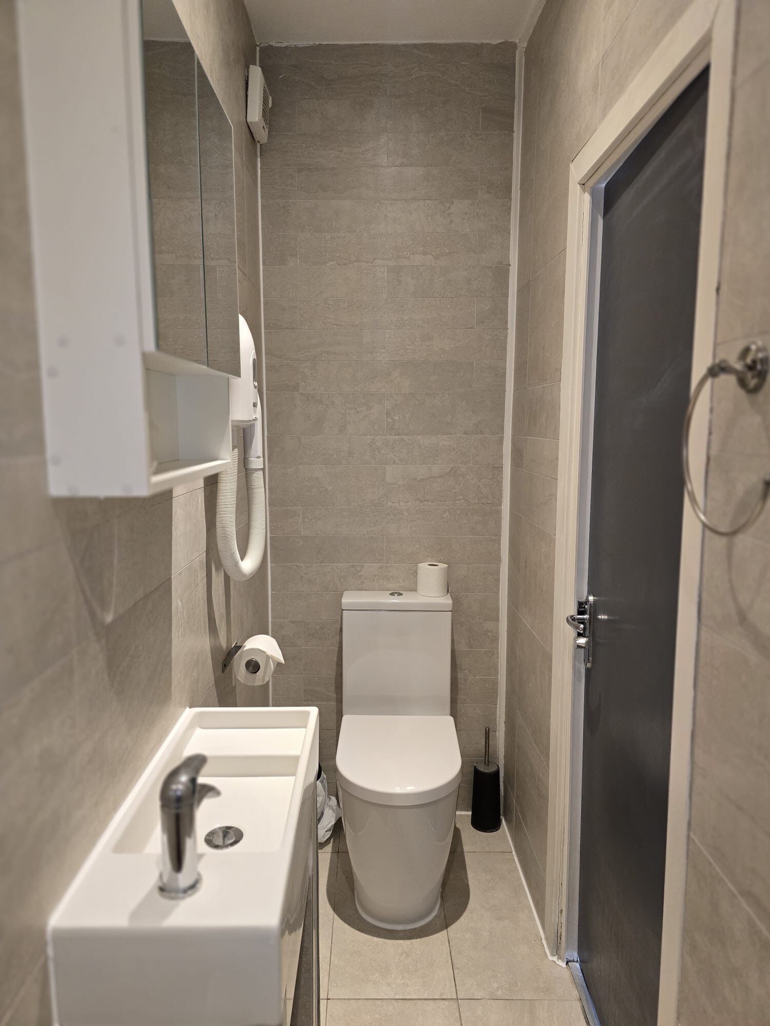 Ein kleines Badezimmer mit Toilette, Waschbecken und einer Duschkabine.