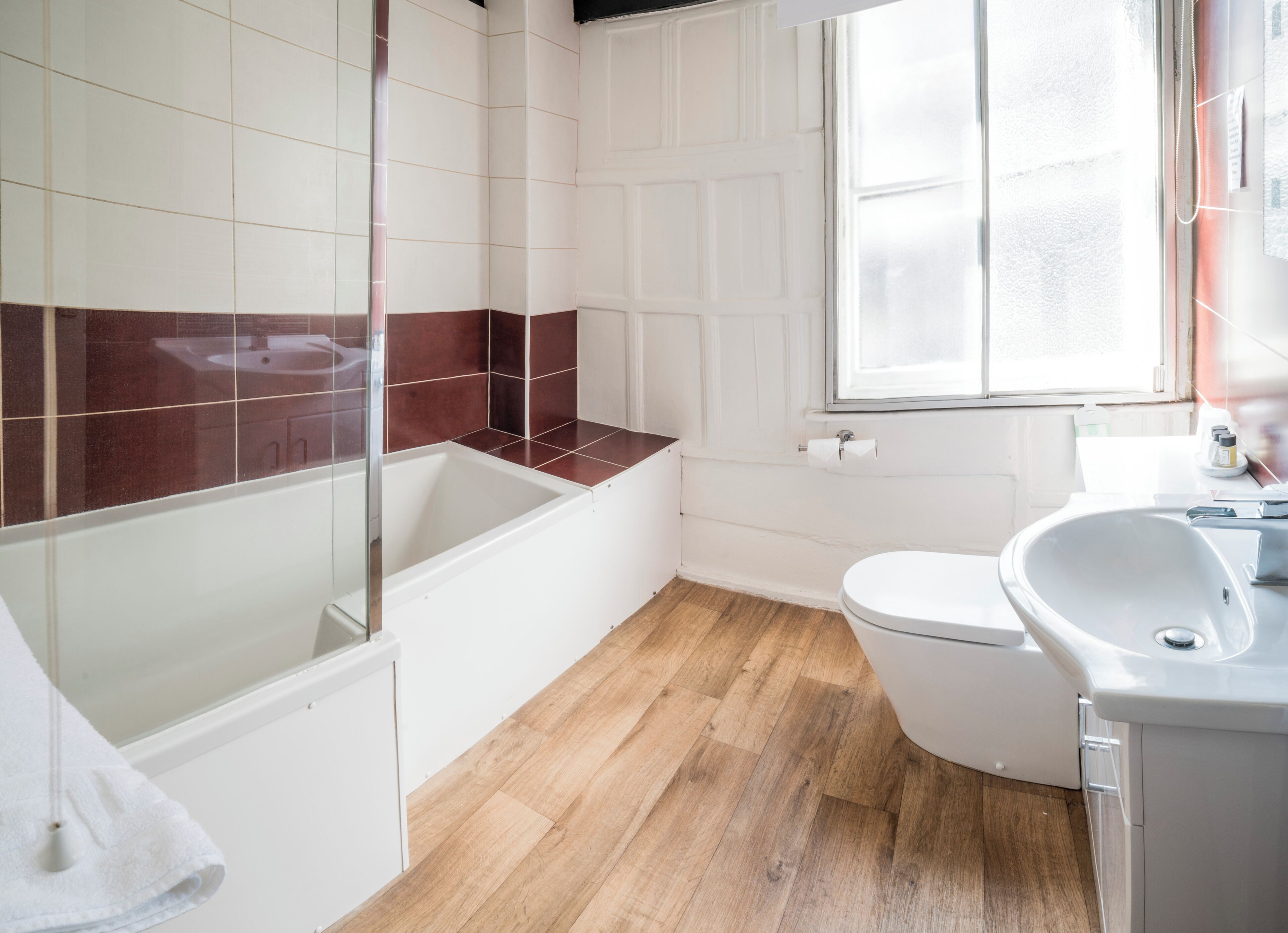 A bathroom with a bathtub, toilet, and sink.