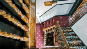 A staircase with a wooden handrail and a sign indicating rooms 1-7. - The White Hart Hotel (St Albans)