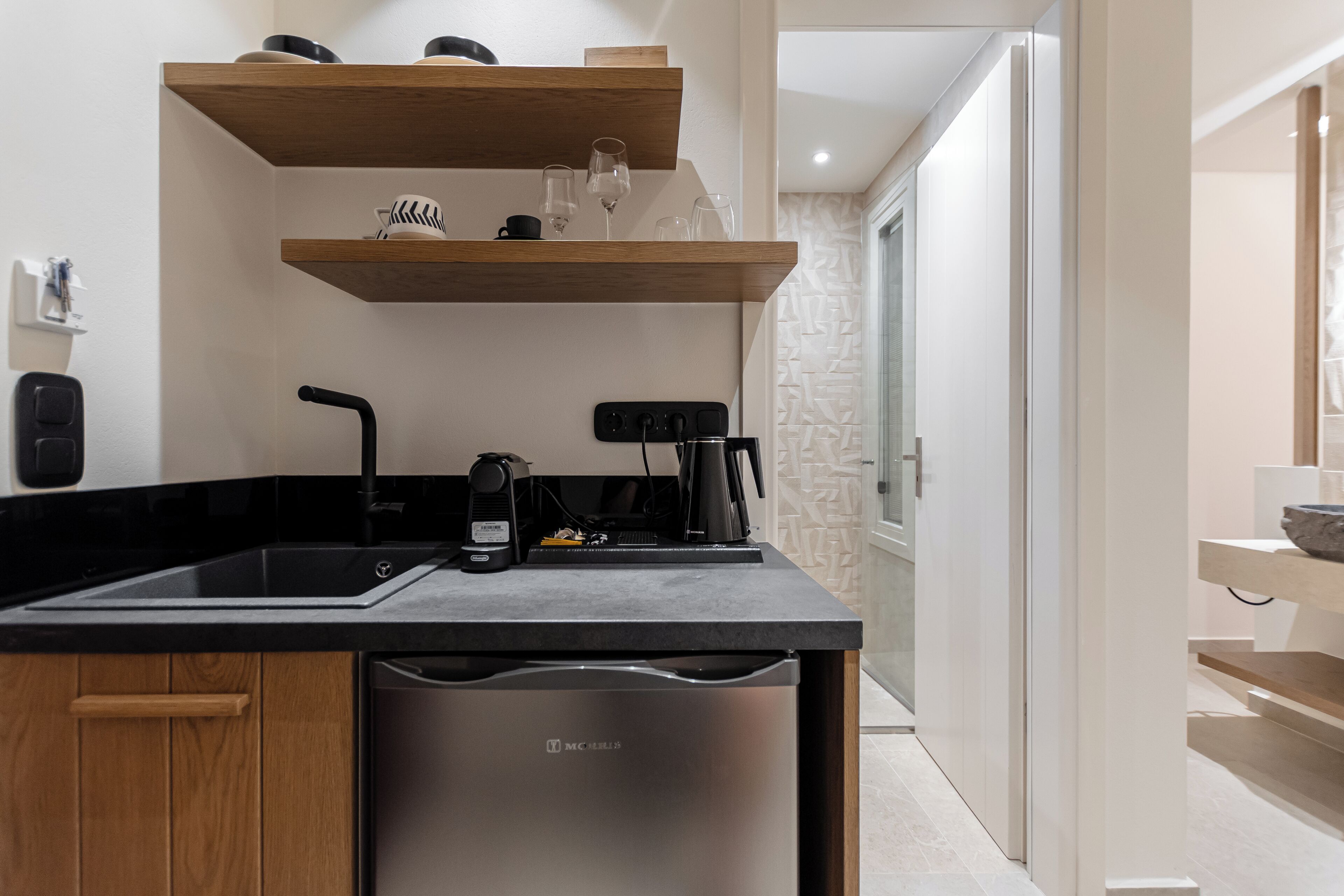 A modern kitchen with a dishwasher, coffee maker, and a built-in espresso machine.