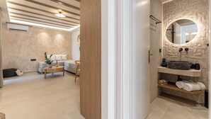 Un baño moderno con un lavabo de piedra, un espejo y un perchero para toallas.