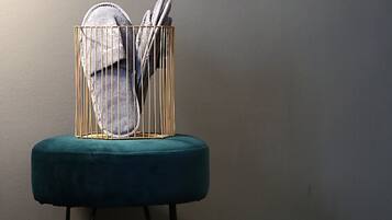 Una silla con una cesta de alambre dorado que contiene un par de zapatos y un par de tijeras.