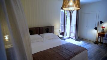Una camera da letto con un letto grande, una lampada a sospensione, un comodino con lampada e vista sull'esterno.