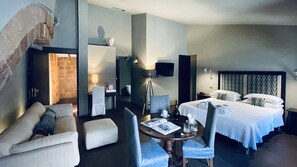 Une chambre d’hôtel équipée d’un lit, d’un bureau, d’une chaise, d’un canapé et d’une télévision.