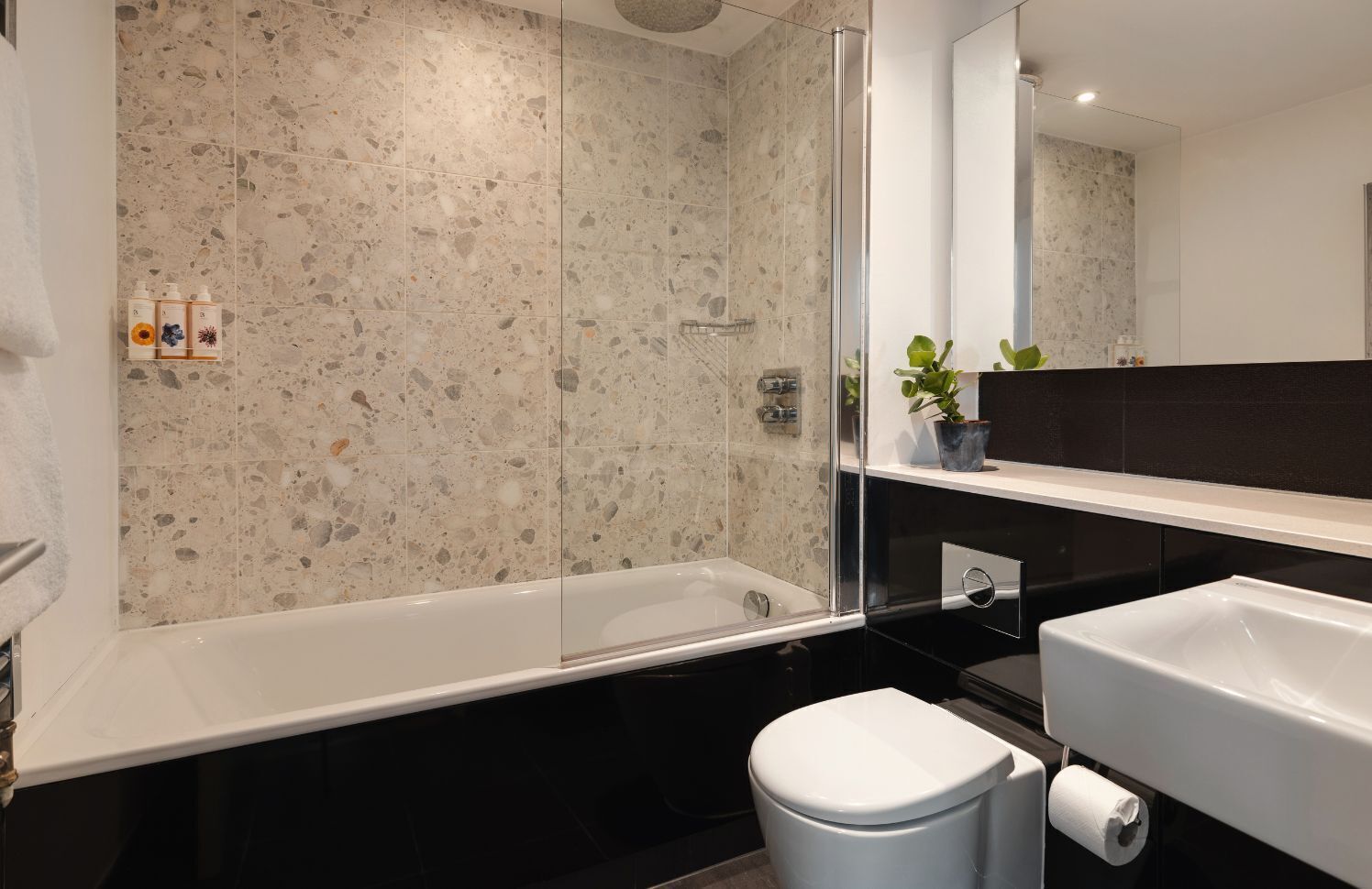 Un bagno moderno con una vasca autonoma, un water e un lavandino.