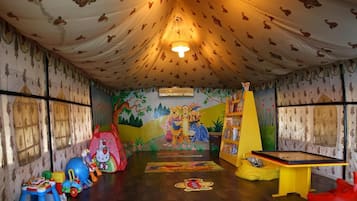 Children can play and explore in this vibrant playroom featuring a whimsical mural and fun toys.
