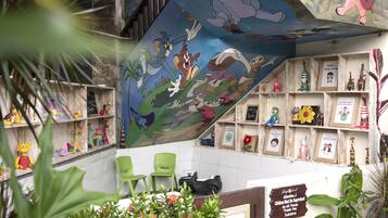 Fun and playful room with a vibrant cartoon mural, wooden shelves, and framed artwork.