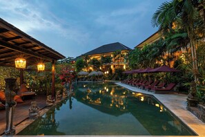 A resort with a central pool, lounge chairs, and tropical vegetation. - Sahaja Sawah Resort (Selemadeg)
