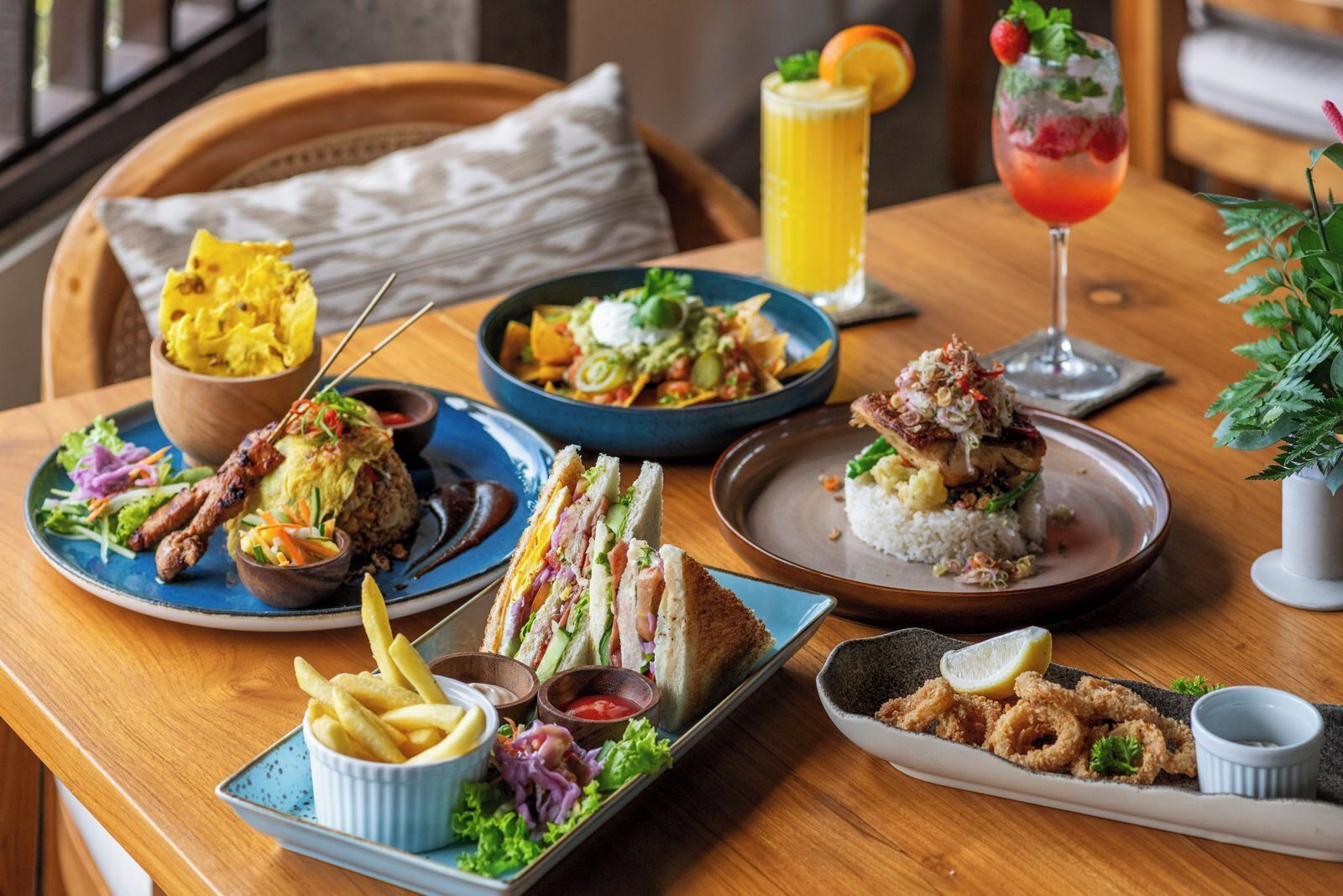 A dining table with various dishes including a sandwich, fries, and a salad.
