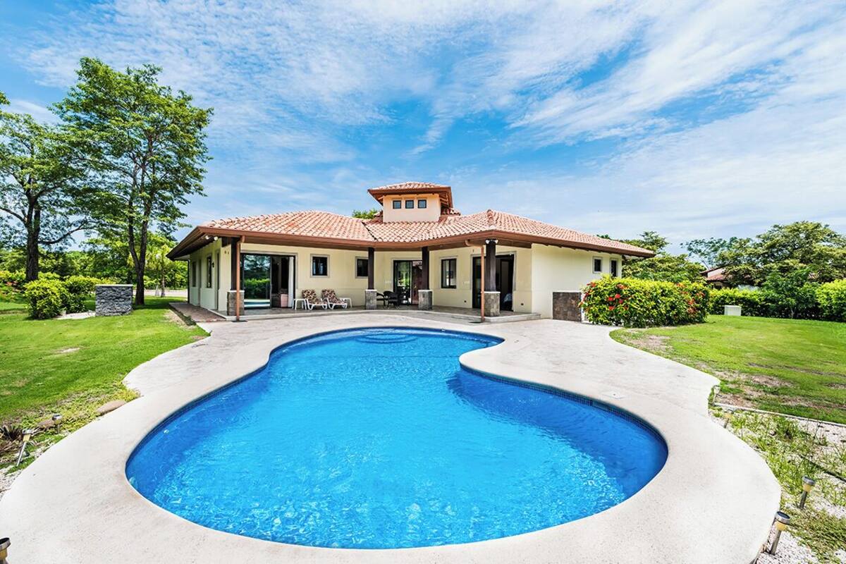 A house with a swimming pool, a patio, and a garden.