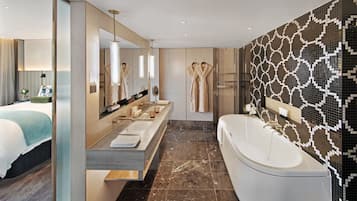 A modern bathroom with a large bathtub, a double vanity with a mirror, and a patterned wall.