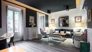 Una sala de estar con sofá, sillones, una mesa de centro y una mesa de comedor.