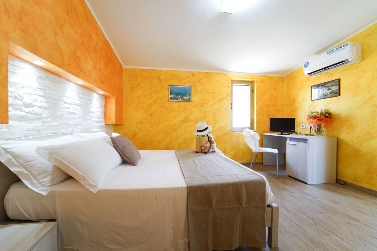 Ein Hotelzimmer mit Bett, Schreibtisch und Stuhl.