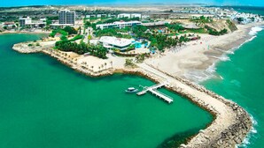 An aerial view of a coastal resort with a marina, beach, and various buildings. - Royal Decameron Punta Centinela (Santa Elena)