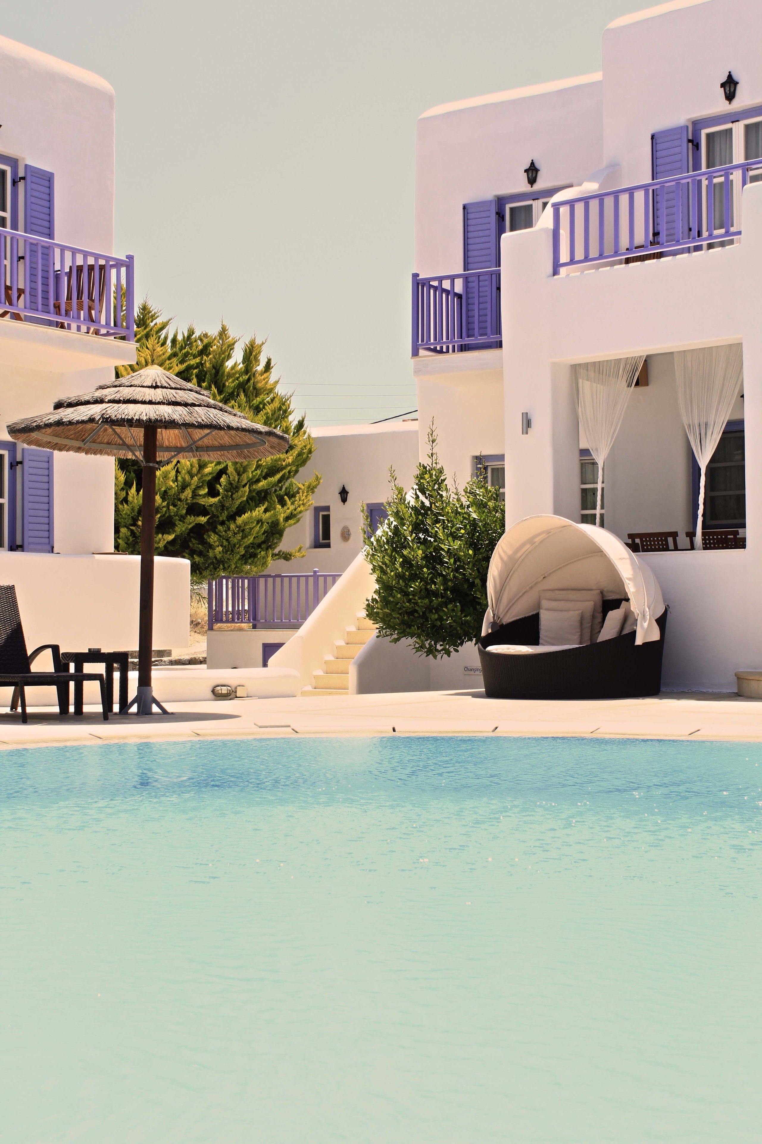 Un resort con piscina, asientos al aire libre y una escalera que lleva a los pisos superiores.