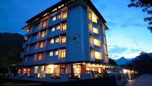 Een meerlaags hotel met een opvallend bord waarop 