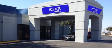 A KIVA HOTEL with a modern design, featuring a large entrance and a parking area.