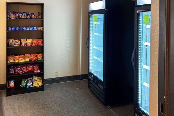 Un distributeur automatique rempli de diverses collations et un congélateur.