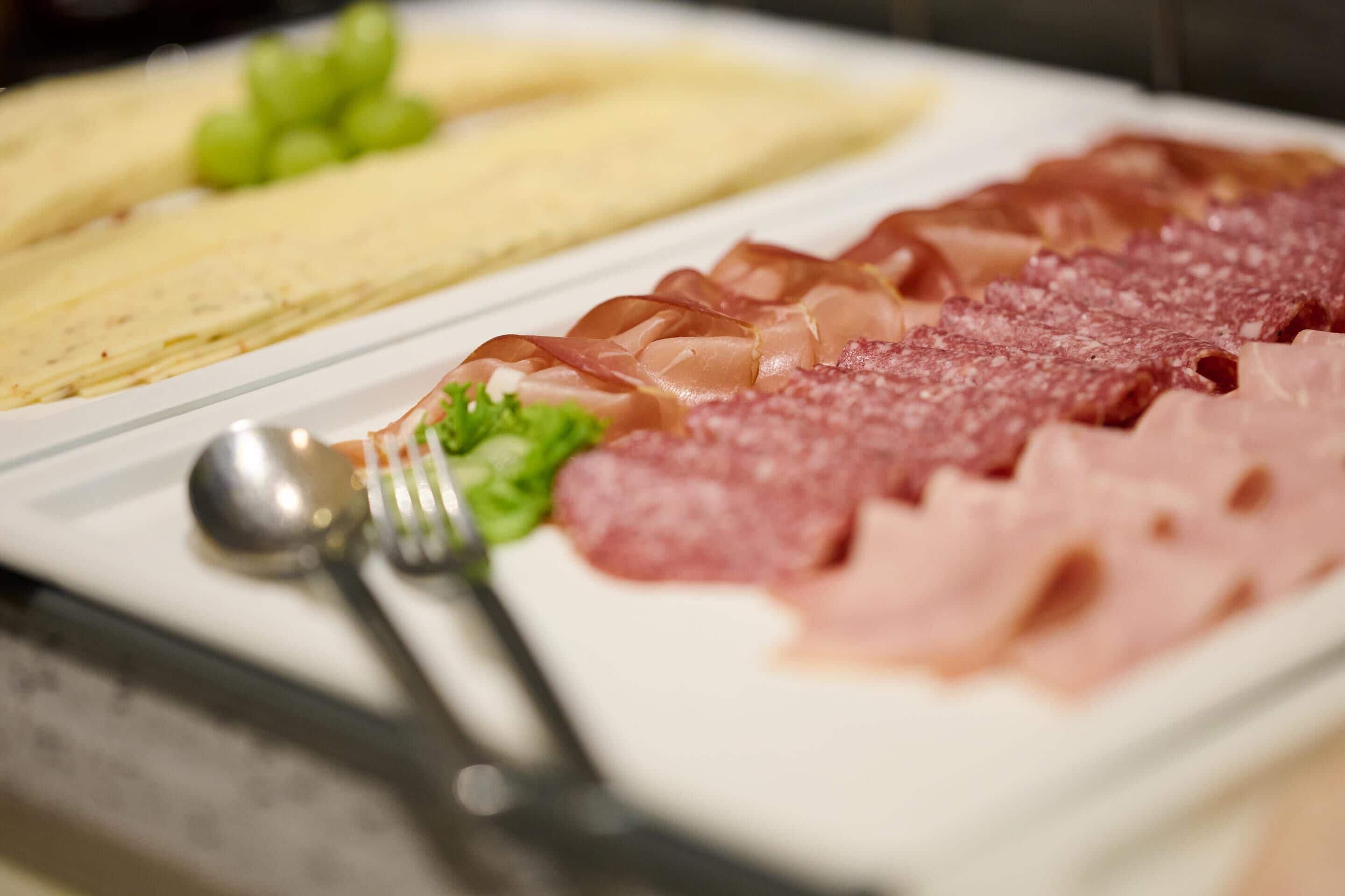 Une assiette contenant différentes sortes de viande et une fourchette.