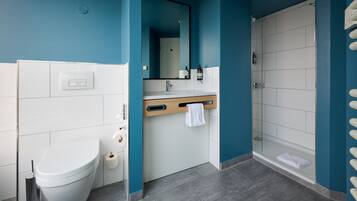 A modern bathroom with a toilet, sink, and shower.