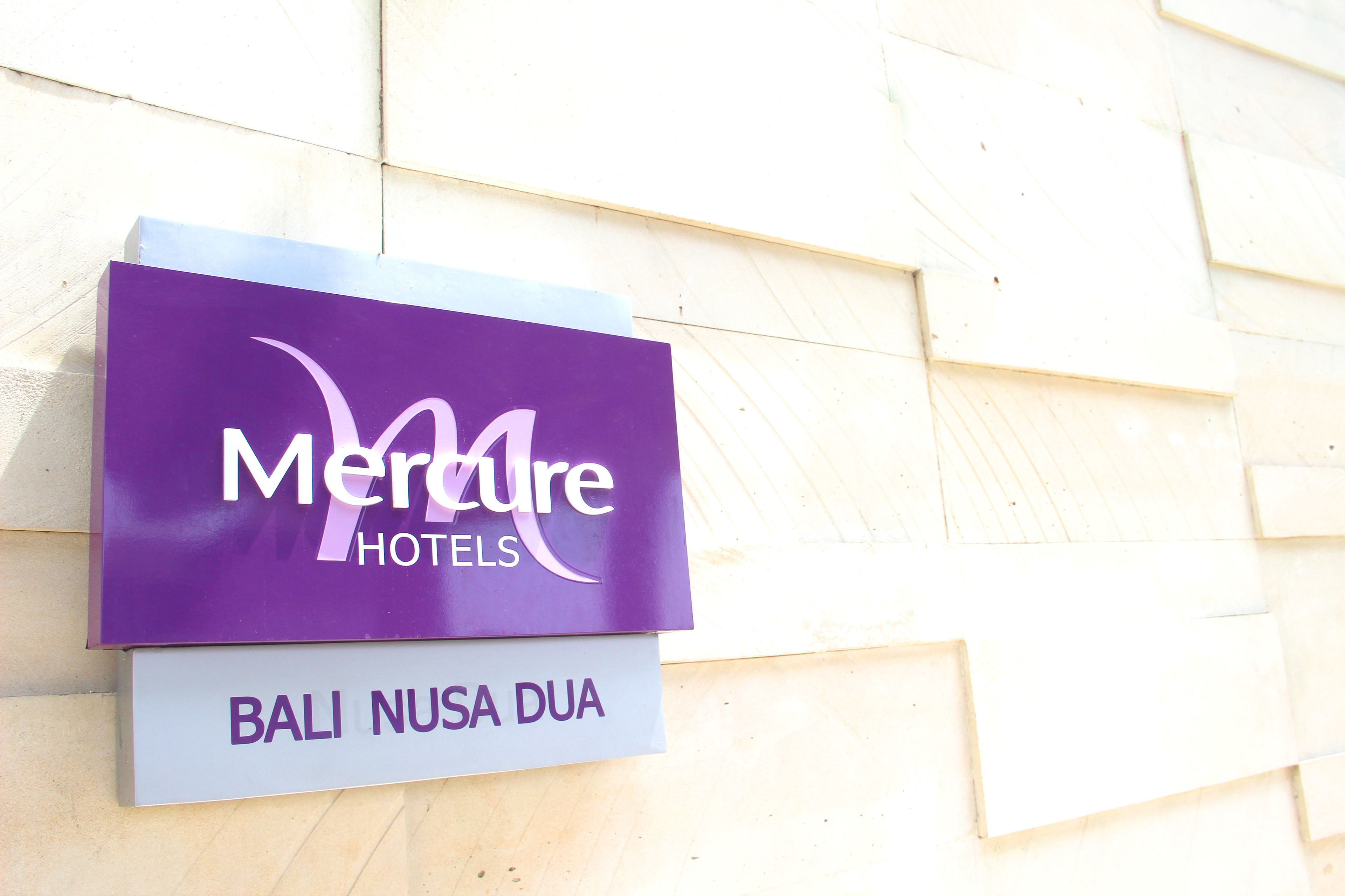 A hotel sign with the name "Merure Hotels" and the location "Bali Nusa Dua".