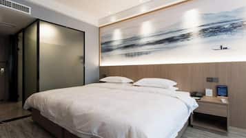 Quarto de hotel moderno com uma cama grande, uma mesa de cabeceira e uma obra de arte na parede.