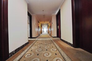 A long, narrow hallway with a patterned carpet and wooden doors on either side. - Cixi Hotel (Ningbo)