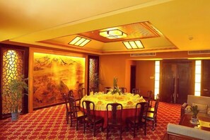 A conference room with a round table, chairs, and a carpeted floor. - Cixi Hotel (Ningbo)