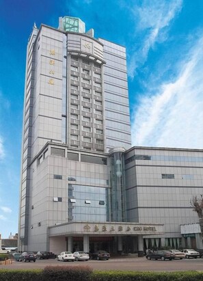 A multi-story hotel with a prominent entrance and a parking lot in front. - Cixi Hotel (Ningbo)