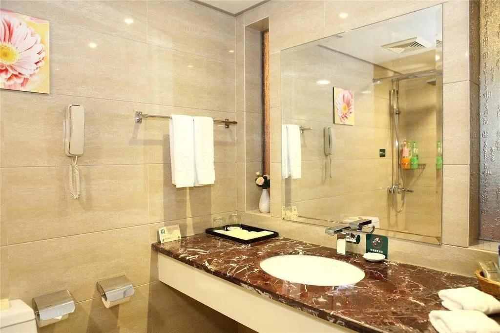 Un bagno moderno con un lavabo in marmo, un ampio specchio, un telefono portatile e un porta asciugamani.