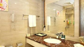 Un bagno moderno con un lavabo in marmo, un ampio specchio, un telefono portatile e un porta asciugamani.