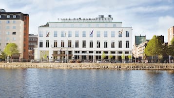 Un hôtel à la façade blanche, doté de nombreuses fenêtres et orné de drapeaux.