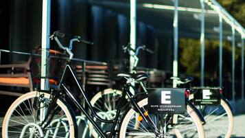 A bicycle parked under a covered area with a sign that reads "E".