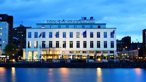 Un hôtel à plusieurs étages, doté d’une façade sobre, de grandes fenêtres et d’une entrée bien visible.
