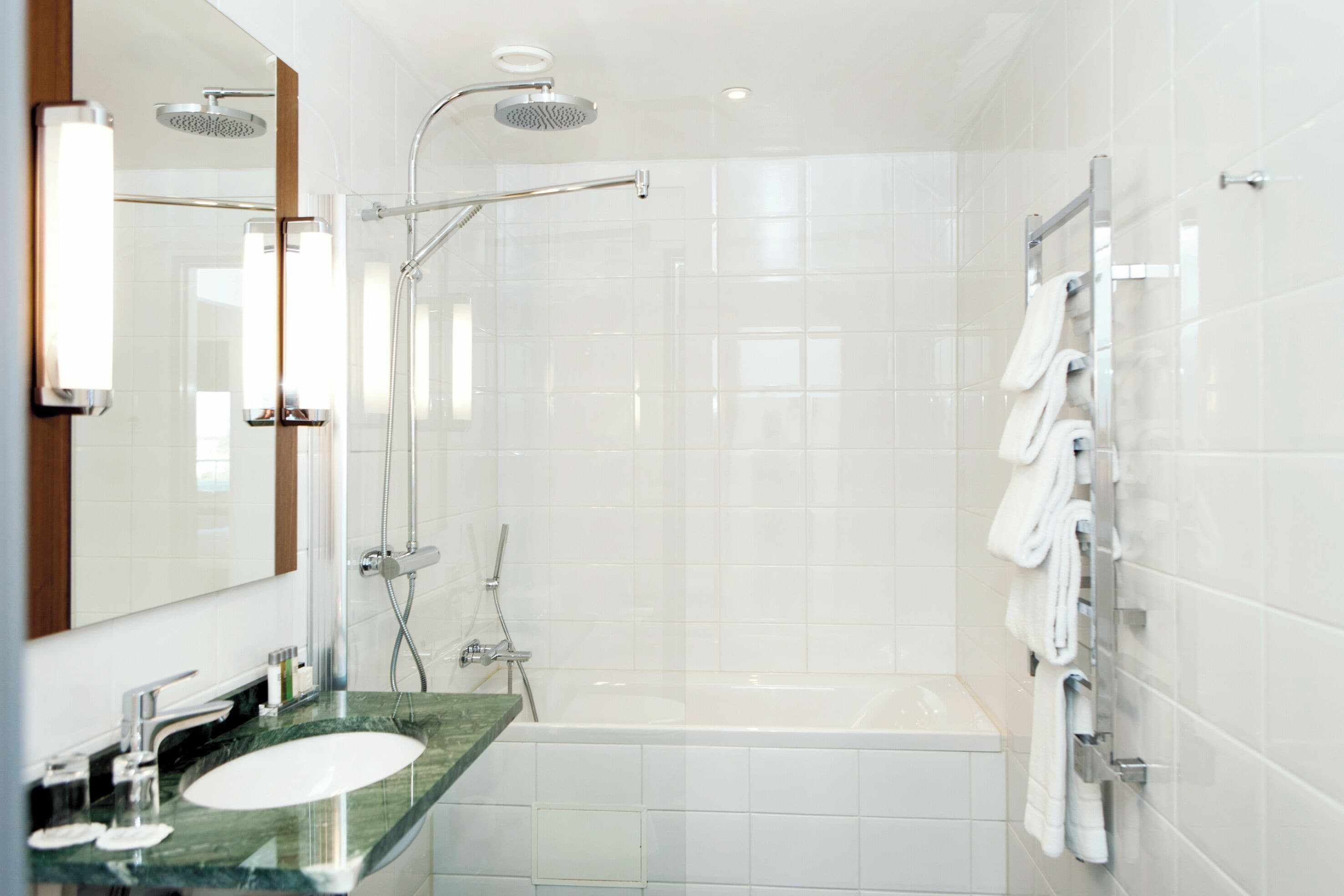 Une salle de bain moderne dotée d’une douche à parois de verre, d’une baignoire et d’un meuble-lavabo avec un évier et un miroir.
