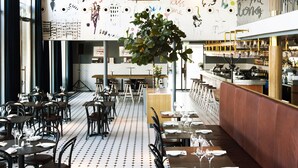 Un restaurant doté d’un long comptoir, de plusieurs tables et de chaises.