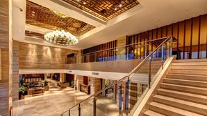 A spacious lobby with a staircase, a reception desk, and a chandelier. - InterContinental Heilong Lake by IHG (Meishan)