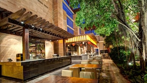 An indoor restaurant with a bar area, seating, and a water feature. - InterContinental Heilong Lake by IHG (Meishan)