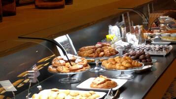 Un bufé con diversos productos horneados y pastelería.
