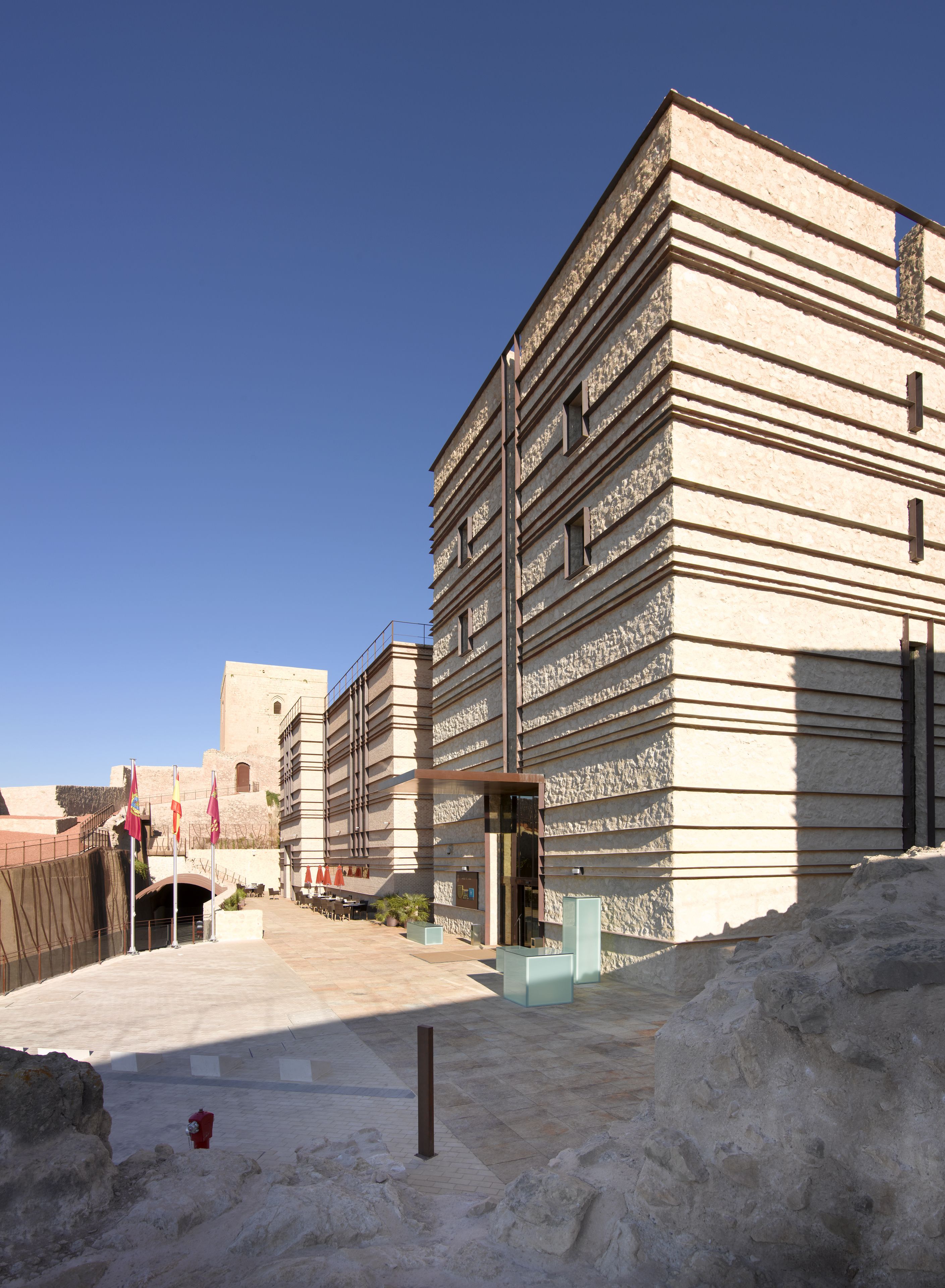 A multi-story building with a modern architectural design, featuring a series of horizontal lines and rectangular windows.