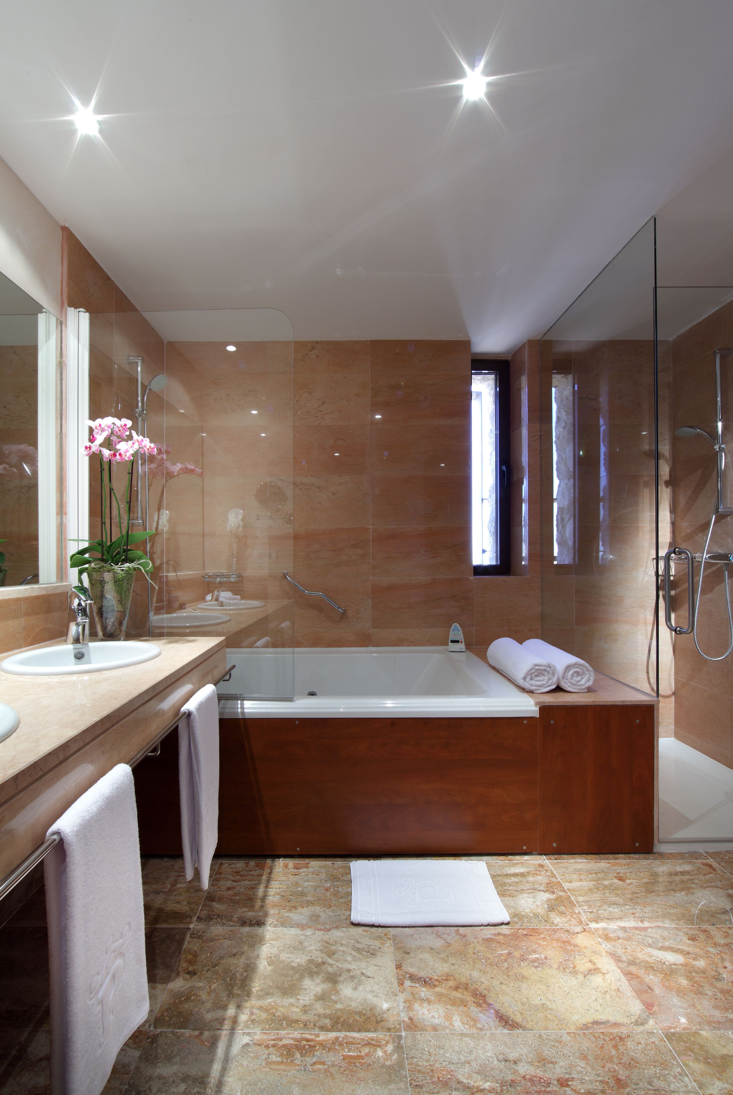 Une salle de bain moderne avec une baignoire, un grand miroir et un meuble-lavabo.