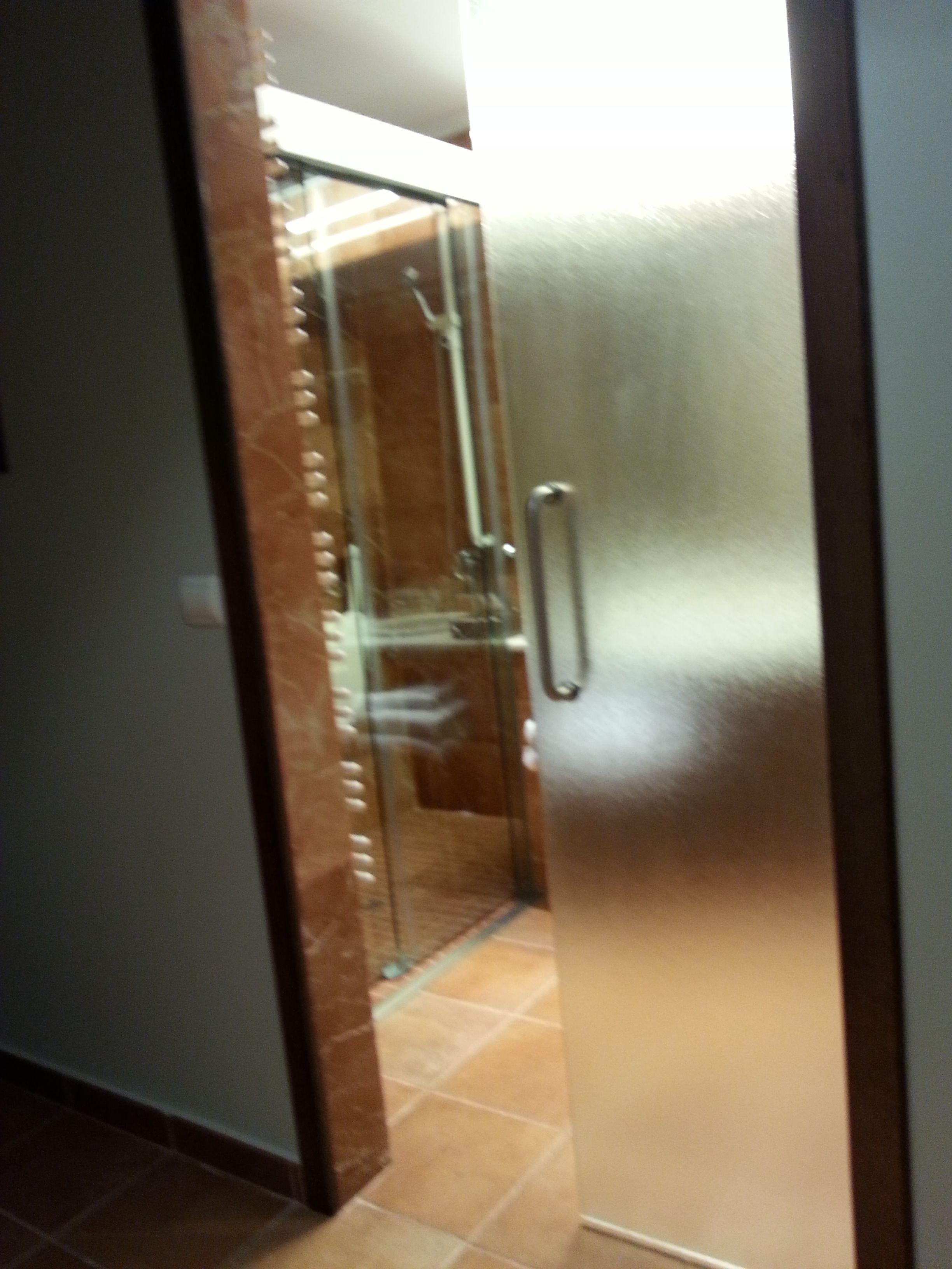 Un passadís amb una porta de vidre que dona a una habitació.