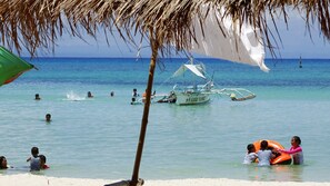 En la playa, playa de arena blanca y camastros 